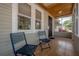 Inviting front porch featuring tiled floors, two chairs, and a screen door for enjoying the outdoors at 560 80Th N Ave, St Petersburg, FL 33702