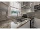 Modern kitchen features a stainless sink, granite countertops, mosaic tile backsplash, and ample counter space at 560 80Th N Ave, St Petersburg, FL 33702