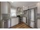 Updated kitchen features stainless steel appliances, mosaic tile backsplash, and granite countertops at 560 80Th N Ave, St Petersburg, FL 33702
