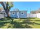 A well-maintained backyard shows the home's back exterior, white fencing, and plenty of green space at 7015 N Dakota Ave, Tampa, FL 33604