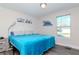 Inviting bedroom with a cozy blue bed, a window providing natural light, and simple yet elegant decor at 7015 N Dakota Ave, Tampa, FL 33604