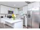 Modern kitchen featuring white cabinets, stainless steel appliances, and a center island with seating at 7015 N Dakota Ave, Tampa, FL 33604