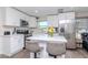 Bright kitchen featuring white cabinets, stainless steel appliances, and a breakfast bar with stylish seating at 7015 N Dakota Ave, Tampa, FL 33604