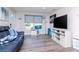 Inviting living room features stylish gray flooring, a large window, and a comfortable blue leather couch at 7015 N Dakota Ave, Tampa, FL 33604