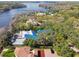 Stunning aerial view of a waterfront estate, showcasing mature trees and a sparkling blue lake at 8510 Lays Cove Pl, Odessa, FL 33556