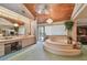 Luxurious bathroom with wood paneled ceiling, chandelier, step-up tub, and vanity with beauty counter at 8510 Lays Cove Pl, Odessa, FL 33556