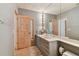 Bathroom with an extended vanity with a spotlight mirror and patterned wallpaper at 8510 Lays Cove Pl, Odessa, FL 33556