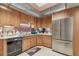 Bright kitchen with stainless steel refrigerator, wooden cabinets, and light countertops at 8510 Lays Cove Pl, Odessa, FL 33556