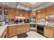 Kitchen with wooden cabinets, white countertops, and standard appliances at 8510 Lays Cove Pl, Odessa, FL 33556