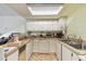 Functional kitchen with white cabinetry, essential appliances, and bright natural light from a skylight at 8510 Lays Cove Pl, Odessa, FL 33556