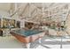 Open-concept great room with bar, ping pong table and vaulted ceilings, providing a spacious and modern living space at 8510 Lays Cove Pl, Odessa, FL 33556