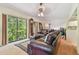 Comfortable living room with leather furniture, a tall clock, and large windows at 8510 Lays Cove Pl, Odessa, FL 33556