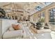 Sun-drenched living room boasts high ceilings, expansive windows, and stylish furnishings, leading to sun room at 8510 Lays Cove Pl, Odessa, FL 33556