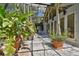 View of the atrium from the side, featuring a long covered walkway with tiled floor and tropical plants at 8510 Lays Cove Pl, Odessa, FL 33556