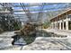 Unique indoor pool features mature landscaping inside a large atrium with tile flooring and metal supports at 8510 Lays Cove Pl, Odessa, FL 33556