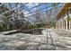 Unique indoor pool features mature landscaping inside a large atrium with tile flooring and metal supports at 8510 Lays Cove Pl, Odessa, FL 33556