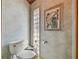 Cozy powder room with a toilet, glass block window, and decorative wall art at 8510 Lays Cove Pl, Odessa, FL 33556