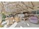 Sun room with vaulted ceilings and exposed beams, features comfortable seating and walls of windows at 8510 Lays Cove Pl, Odessa, FL 33556