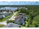 Aerial view of a single-Gathering home near a lake and surrounded by lush greenery and neighboring houses at 12906 Tar Flower Dr, Tampa, FL 33626