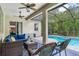 Relax on the covered patio with a ceiling fan, outdoor seating and pool views at 12906 Tar Flower Dr, Tampa, FL 33626