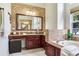 Luxurious bathroom with double sinks, granite countertops, brick accent wall and soaking tub at 12906 Tar Flower Dr, Tampa, FL 33626