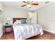 Comfortable bedroom featuring hardwood floors, ceiling fan, and a nightstand with decor at 12906 Tar Flower Dr, Tampa, FL 33626