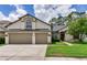 Beautiful single-Gathering home with a well-manicured lawn, two-car garage, and lush green trees in the background at 12906 Tar Flower Dr, Tampa, FL 33626