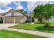Beautiful single-Gathering home with a well-manicured lawn, two-car garage, and lush green trees in the background at 12906 Tar Flower Dr, Tampa, FL 33626