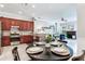 Open-concept kitchen and dining area with stainless steel appliances and wood cabinets at 12906 Tar Flower Dr, Tampa, FL 33626