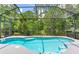 Inviting screened-in pool area with sparkling blue water and lush green landscaping for a private backyard oasis at 12906 Tar Flower Dr, Tampa, FL 33626