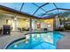 Inviting screened-in pool area with patio seating, a grill, and plenty of room for outdoor entertaining at 12906 Tar Flower Dr, Tampa, FL 33626