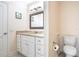 Bright bathroom featuring a granite countertop vanity, white cabinets, and modern fixtures at 15124 Springview St, Tampa, FL 33624