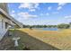 Expansive backyard featuring a serene lake view, a lush lawn, and direct water access at 1730 Sunset Point Rd, Clearwater, FL 33755