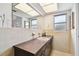 Bright bathroom with wide mirror and white tiling, featuring a sink with storage, and open layout at 1730 Sunset Point Rd, Clearwater, FL 33755
