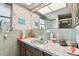 Bathroom featuring a mirror with marine life wallpaper and a sink with a marbled countertop at 1730 Sunset Point Rd, Clearwater, FL 33755