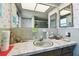 Bathroom featuring a mirror with marine life wallpaper and a sink with a marbled countertop, with decor at 1730 Sunset Point Rd, Clearwater, FL 33755