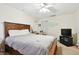 Bedroom features a wooden bed frame, carpeted flooring, a closet, and soft lighting at 1730 Sunset Point Rd, Clearwater, FL 33755