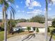 Welcoming single-story home with palm trees, a circular driveway, and stunning water views at 1730 Sunset Point Rd, Clearwater, FL 33755