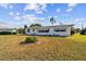 Front yard featuring a well-maintained lawn and some mature trees, enhancing the home's curb appeal at 1730 Sunset Point Rd, Clearwater, FL 33755