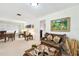 Living room featuring cozy wicker furniture, artwork, and neutral carpeting at 1730 Sunset Point Rd, Clearwater, FL 33755