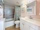 Cozy bathroom with tiled shower, seashell-themed shower curtain, and white vanity at 18304 Gulf Blvd # 217, Redington Shores, FL 33708