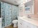 Cozy bathroom with tiled shower, seashell-themed shower curtain, and white vanity at 18304 Gulf Blvd # 217, Redington Shores, FL 33708