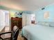 Bright bedroom with blue walls, wood flooring, and antique furnishings at 18304 Gulf Blvd # 217, Redington Shores, FL 33708