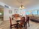 Dining room with wood table, chairs, chandelier, and view of living room and ocean at 18304 Gulf Blvd # 217, Redington Shores, FL 33708
