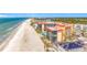 View of condo building with beach access and a community pool, located near a commercial street at 18304 Gulf Blvd # 217, Redington Shores, FL 33708