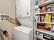 Laundry area featuring a stacked washer and dryer, with storage shelving on the side for supplies and utilities at 18304 Gulf Blvd # 217, Redington Shores, FL 33708