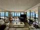 Bright living room featuring wood floors, stylish furnishings, and expansive windows with a view of the Gulf at 18304 Gulf Blvd # 217, Redington Shores, FL 33708