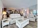 Comfortable living room featuring white furniture, and an open layout to dining area and kitchen at 18304 Gulf Blvd # 217, Redington Shores, FL 33708