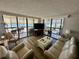 Bright living room featuring wood floors, stylish furnishings, and expansive windows with a view of the Gulf at 18304 Gulf Blvd # 217, Redington Shores, FL 33708