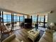 Open living room with wood flooring, modern furnishings, and floor-to-ceiling windows offering an ocean view at 18304 Gulf Blvd # 217, Redington Shores, FL 33708